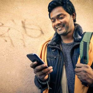 Young indian man holding mobile phone