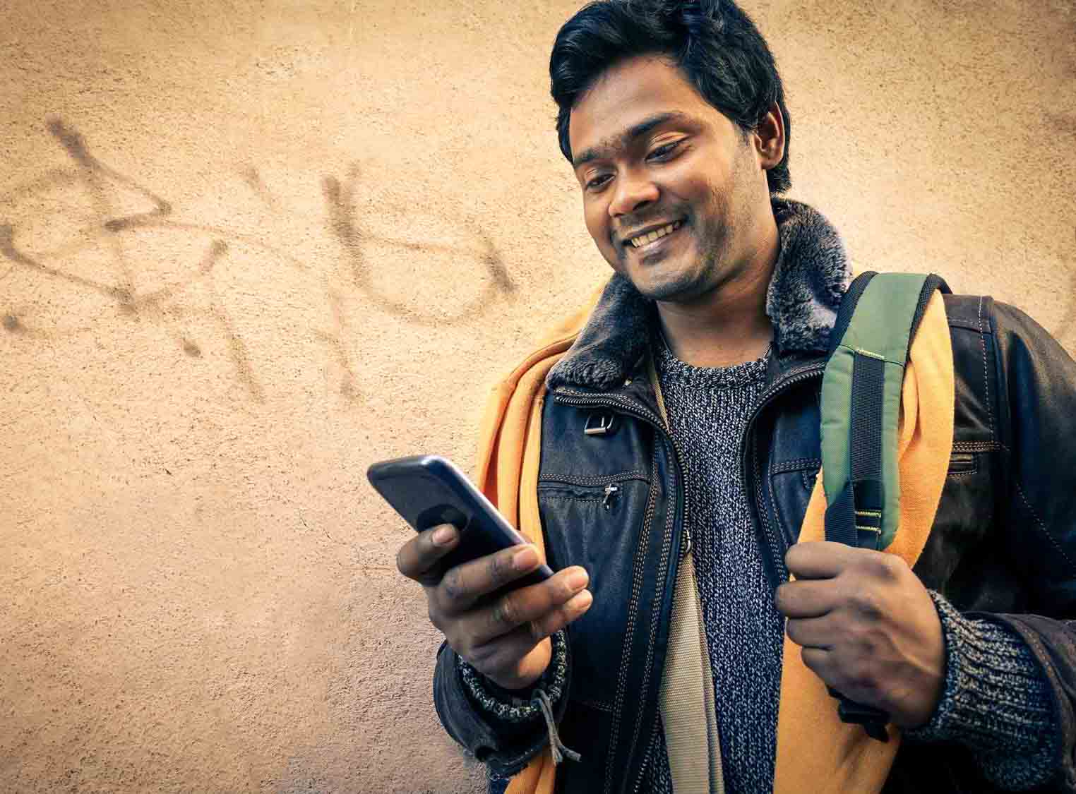 Young indian man holding mobile phone